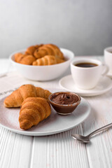 coffee and croissants, chocolate cream, french press on the table, morning breakfast 