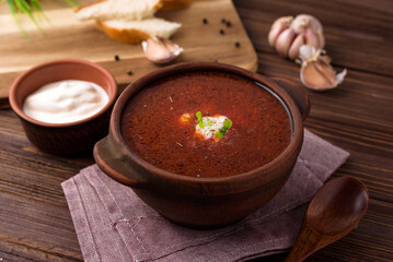 red beetsoup, traditional ukrainian borshch and garlic, wooden spoon