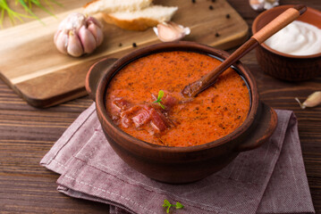 red beetsoup, traditional ukrainian borshch and garlic, wooden spoon