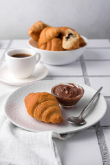 coffee and croissants, chocolate cream, french press on the table, morning breakfast 