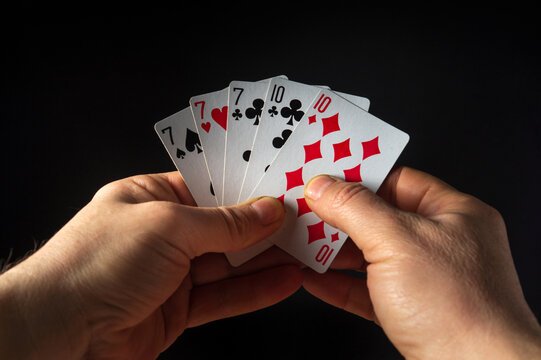 The player hands hold playing cards with a winning combination of full house or full boat. Success at poker.