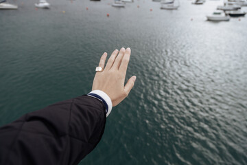 A hand on blue sea background.Person's hand reaching the ocean.