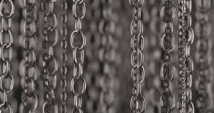 Shaking metal chains hanging vertically background.