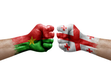 Two hands punch to each others on white background. Country flags painted fists, conflict crisis concept between burkina faso and georgia