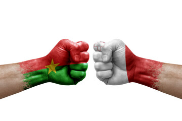 Two hands punch to each others on white background. Country flags painted fists, conflict crisis concept between burkina faso and malta