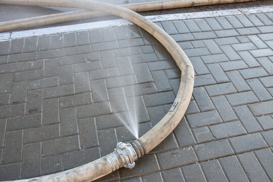 Expired Fire Hose , water leaking. water leaking from hole in a industrial hose. .fire hose lies on the street