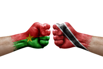 Two hands punch to each others on white background. Country flags painted fists, conflict crisis concept between burkina faso and tobago