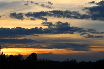 Autumn sunset with clouds, landscape as background. 