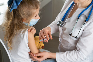 vaccination of children, a little girl at a doctor's appointment, an injection in the arm, the conce