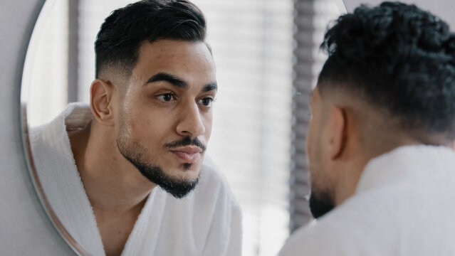 Mirror reflection portrait arabian arab indian bearded man washing face male wet face with hot cold water guy morning showering skincare routine beauty wash getting ready for new day in bathroom hotel