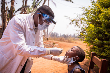 An african doctor does a swab test on a child to see if he positive to coronavirus. Covid-19 test...