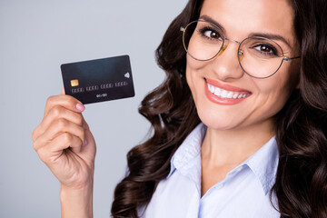 Close up photo of optimistic brunette curly mature lady hold card wear bright look spectacles...