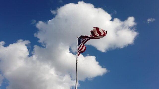 American USA national flag in the wind on a beautiful cloudy sunny day