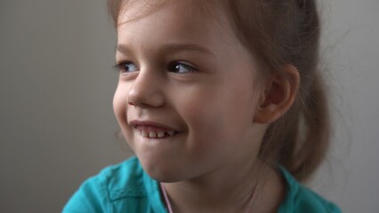 Portrait Funny little close up view happy preschool girl smiling child looking away thoughtfully, pretty natural face.sincere emotions of ashamed, embarrassed clean skin dermatology, pediatric