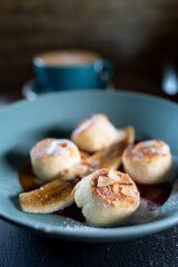 fresh coffee and cheese pancakes with banana, mango and berry sauce