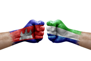 Two hands punch to each others on white background. Country flags painted fists, conflict crisis concept between cambodia and sierra leone