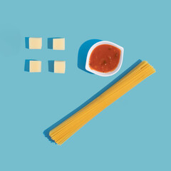 Spagetti, tomato sauce and cheese. Blue  background. Copy space. Top view.