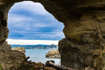 Blue water of Tolaga Bay through Hole in the Wall tourist destination and landmark.