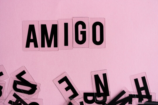 letras formando la palabra Amigo sobre fondo rosado y letras desordenadas debajo