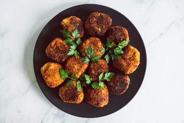 vegan pesto arancini fried risotto balls with fresh parsley as topping, healthy plant-based food