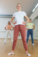 Obraz premium Portrait of positive smiling european woman and people dancing in modern studio