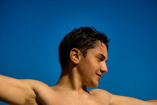 Wet young man under the sunny blue sky