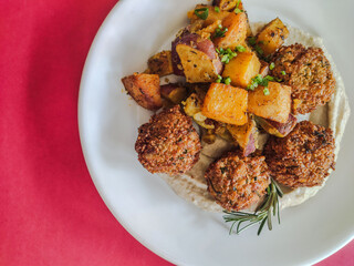 Falafel dish with pumpkin top view and red backgroud