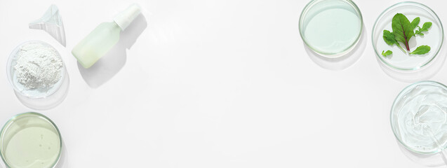 laboratory developed cosmetic with natural ingredients, clay powder, green leaves and perti dishes with medium. testing of efficiency and safety. banner, copy space