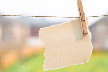 Blank torn paper hanging on a string with clothespin ready for text