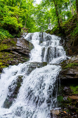 Beautiful view of waterfall with water flowing through rock in green nature forest during spring, Beautiful deep forest waterfall