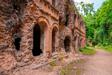 Walking path through ruins of old fortification fort on sunny day, Remains of ancient old fort with crumbling bricks wall