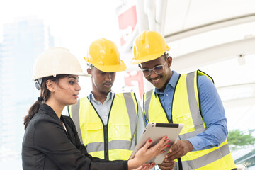 Group of Engineer Worker Wearing Safety Uniform and Hard Hat Uses Tablet Computer. Happy Successful. Businesswomen working with tablet checklist