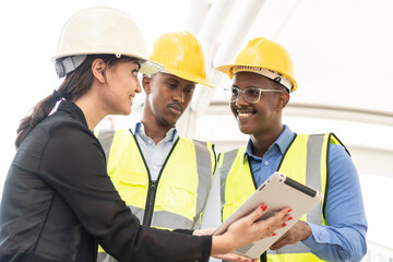 Group of Engineer Worker Wearing Safety Uniform and Hard Hat Uses Tablet Computer. Happy Successful. Businesswomen working with tablet checklist