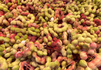 image of pile of Pink Manila tamarind fruit (science name :Pithecellobium dulce) in the market. Popular fruit in southeast asia,