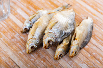 Air-dried salted gutted fish roach on wooden background, russian cuisine