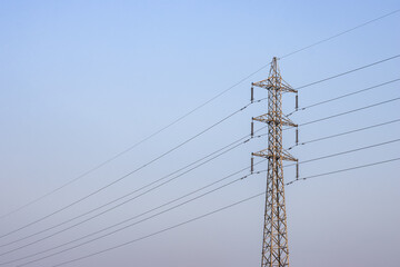 High voltage electricity transmission tower under the blue sky with copy space
