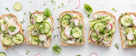 A row of fresh cucumber and radish tartines ready for eating.