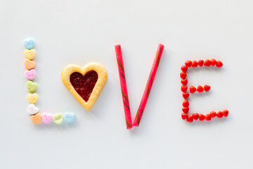 Valentine's confections used to make the word love, against a white background.
