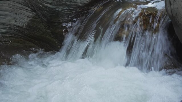 Close-up shot of a waterfall cascading down a rock in slow motion, laterite palace, Pua Nan.