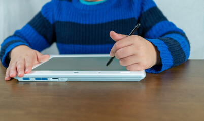 タブレット端末で学習する子供。通信教育のイメージ、オンライン教育