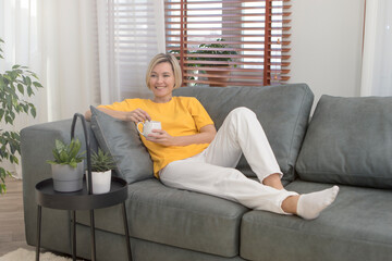 Obraz premium Happy young couple sitting and watching TV at home