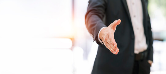 Businessman extending hand to shake.