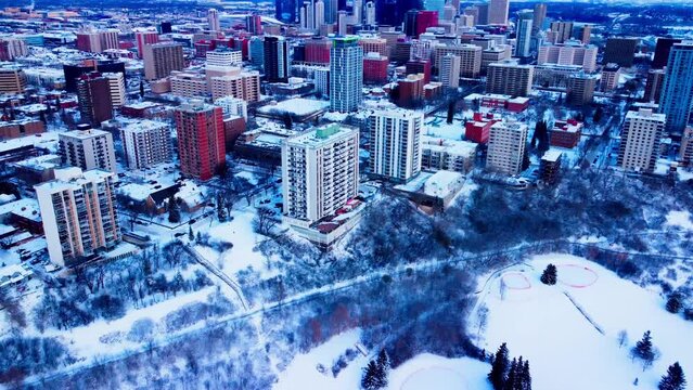 Edmonton Alberta Canada winter aerial flyout backwards from the downtown snow covered residential westside of the Oliver neighborhood overlooking the most densely populated area in the afternoon2-2
