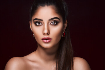 portrait of pretty woman who advertises luxury jewelry isolated on dark background. Jewelry concept