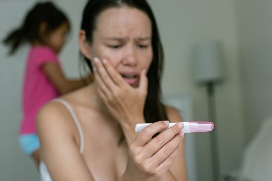 Tired sick woman checking her temperature. Pregnancy.