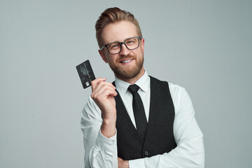Cheerful businessman with credit card in studio