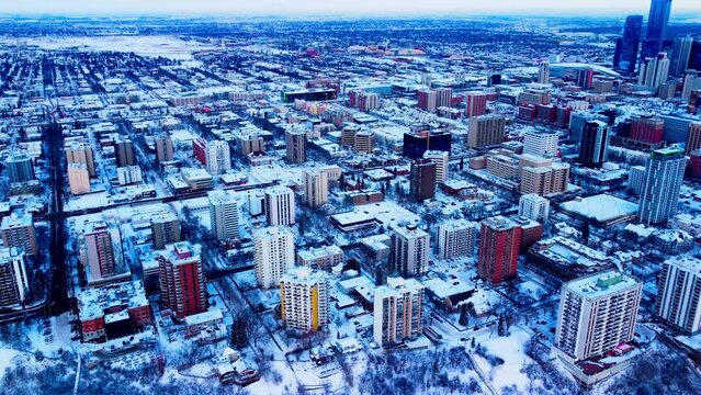 Edmonton winter downtown snow covered potential residential commercial and retail properties available for development in a dense West residential community city core steady aerial drone rise 1-2