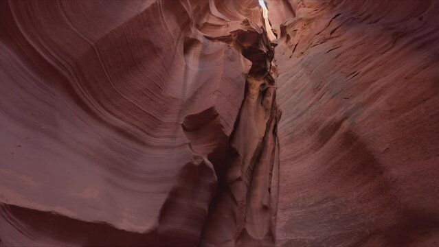 Slot canyon with high walls beyond clear blue skyline. Cinematic scenery inside narrow Upper Antelope Canyon as seen from below. High quality 4k footage