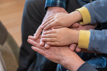 Grandma and grandpa and grandson holding hands. Six palms touching each other.