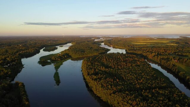 Aerial view overlooking islands on the Tornionjoki river, golden hour in Lapland - tracking, drone shot